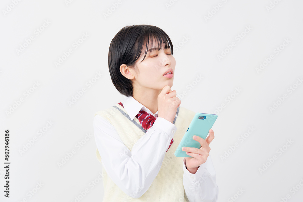 白背景でスマホを持って悩む女子高生