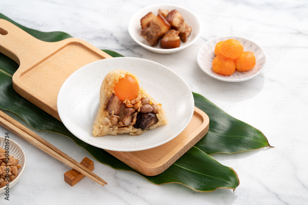 Zongzi, rice dumpling for Dragon Boat Festival on bright marble table background with ingredient.