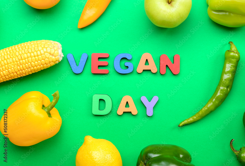 Text VEGAN DAY, different vegetables and fruits on green background, closeup