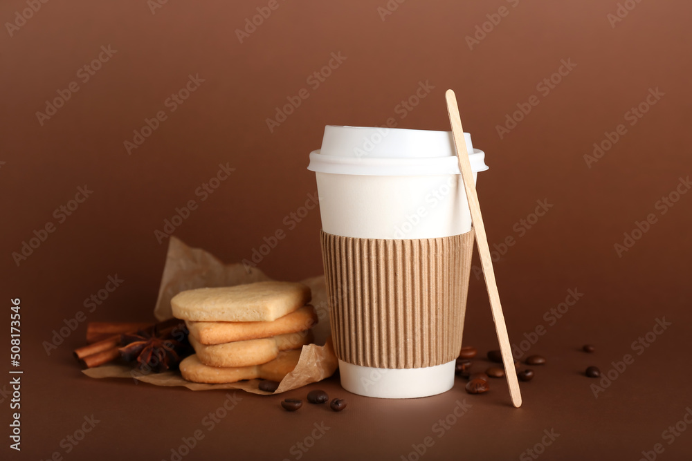 Takeaway paper cup and cookies on brown background