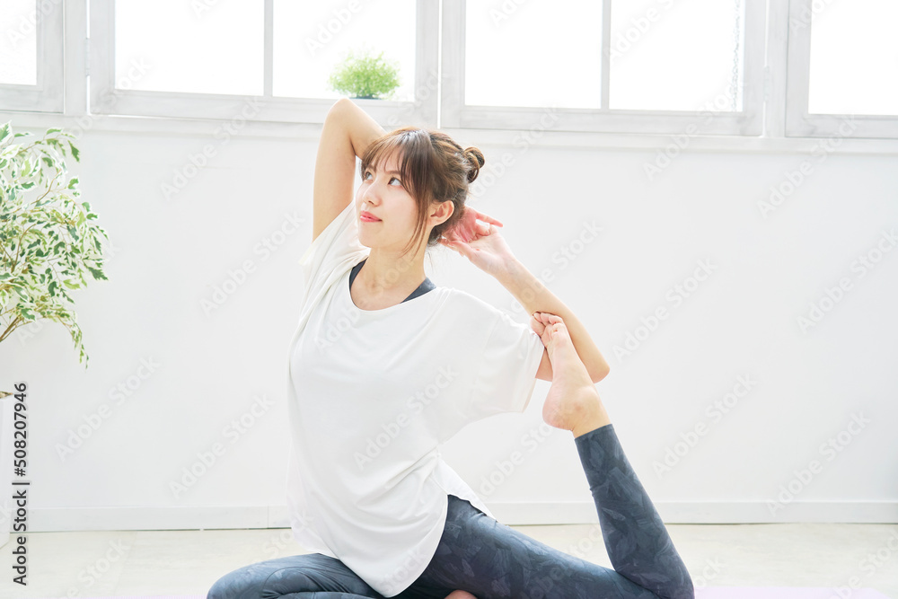 自宅でヨガの鳩のポーズをする女性