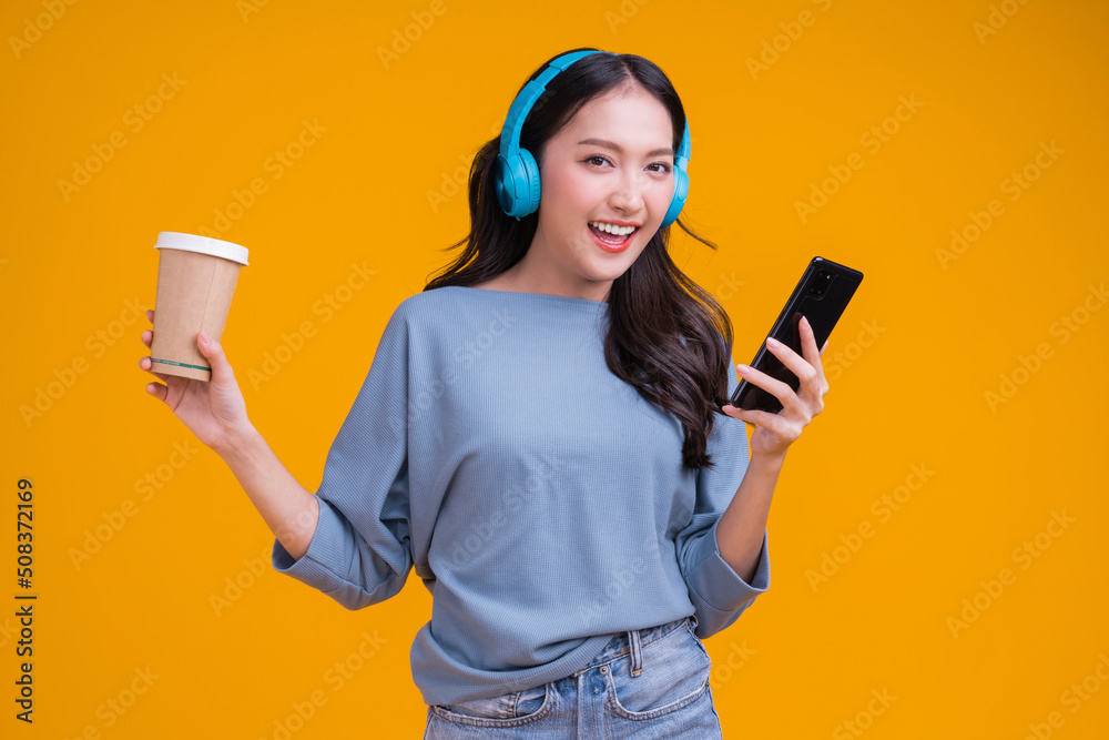 happiness carefree asian female woman teen wearing headphone hand hold coffee cup listen dance joyfu