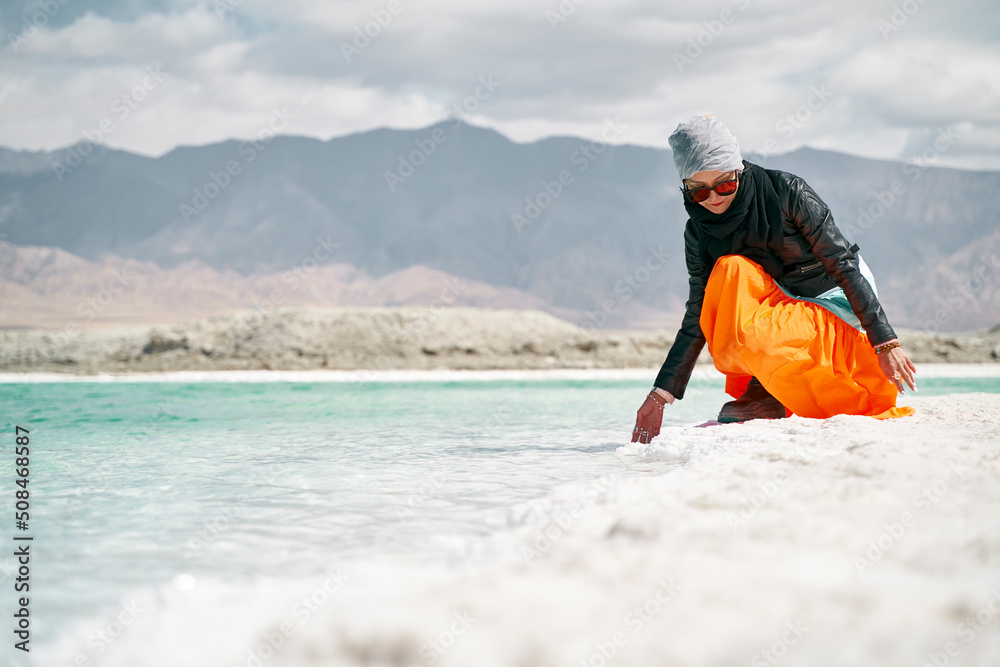 asian woman touching the water of a salt lake