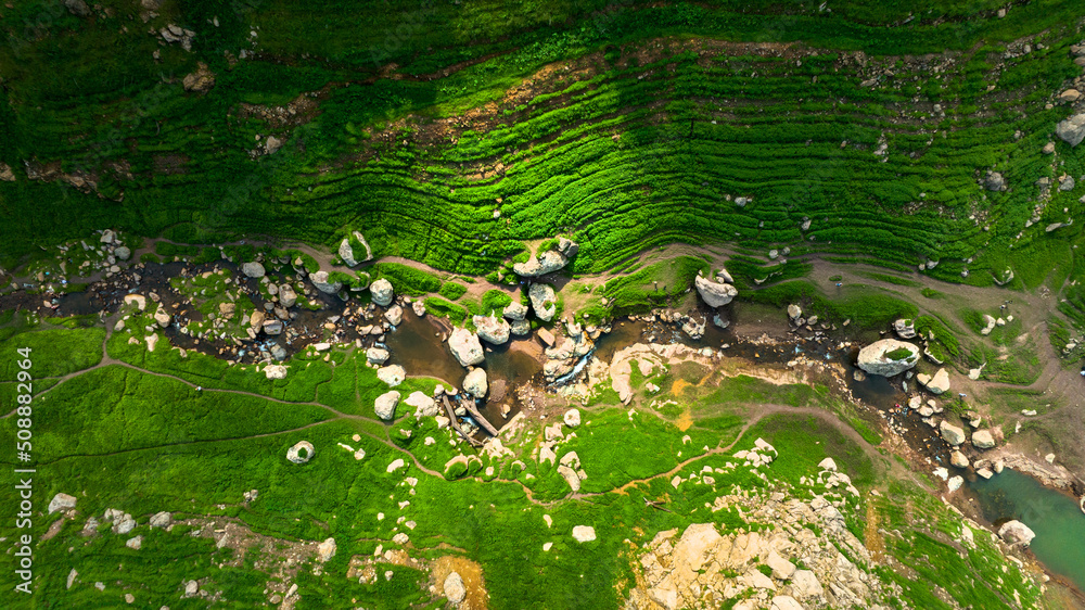 野生森林山上美丽的天然溪流和绿色的草地鸟瞰图