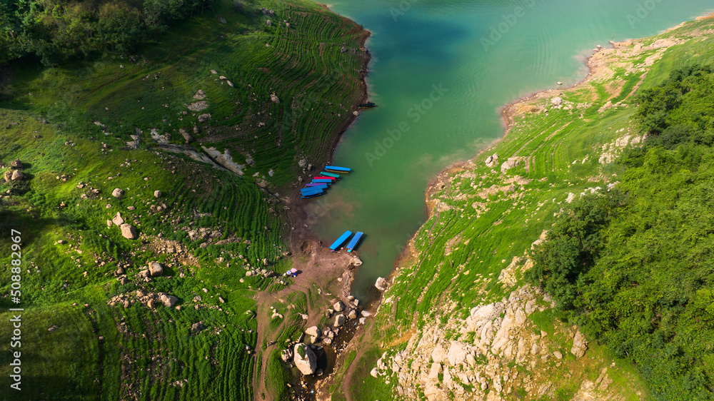 Aerial view of beautiful natural water stream  and green field of grass in the wild forest mountain 