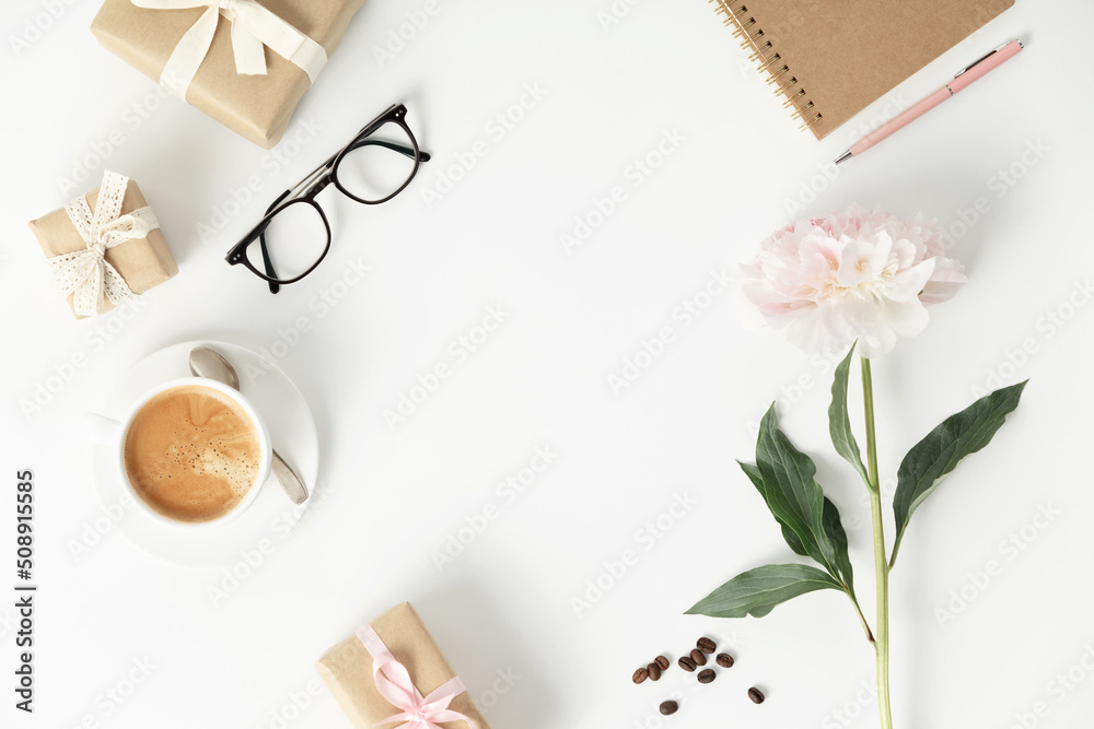 Festive arrangement: gift boxes, coffee, notebook, mobile phone, glasses and flowers  on a white tab