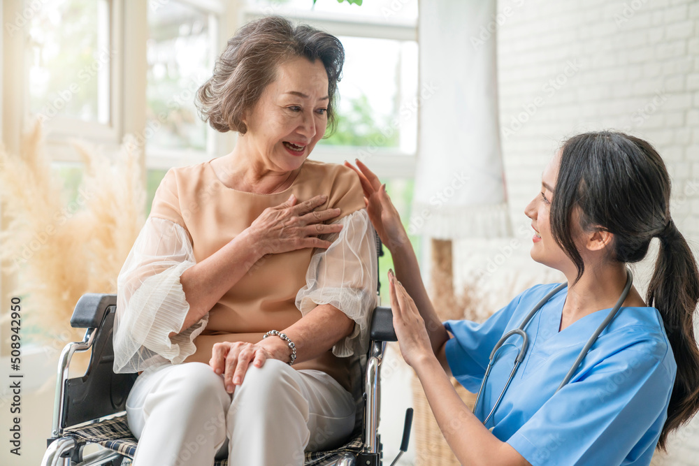 asian young caregiver caring for her elderly patient at senior daycare Handicap patient in a wheelch