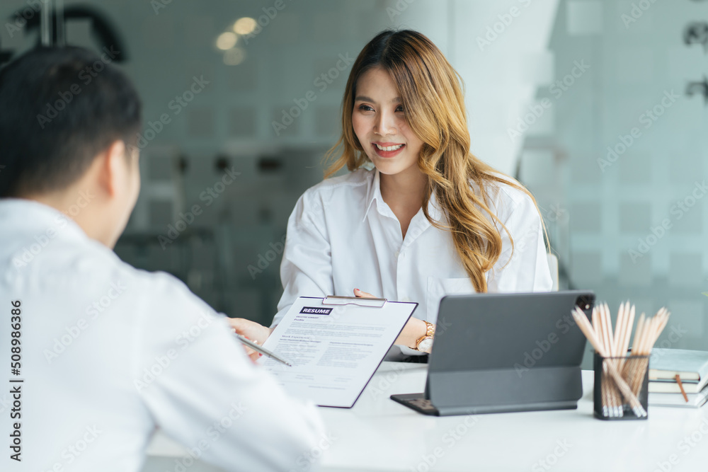 Close-up of asian business woman candidate giving her CV to human resource manager on a job intervie