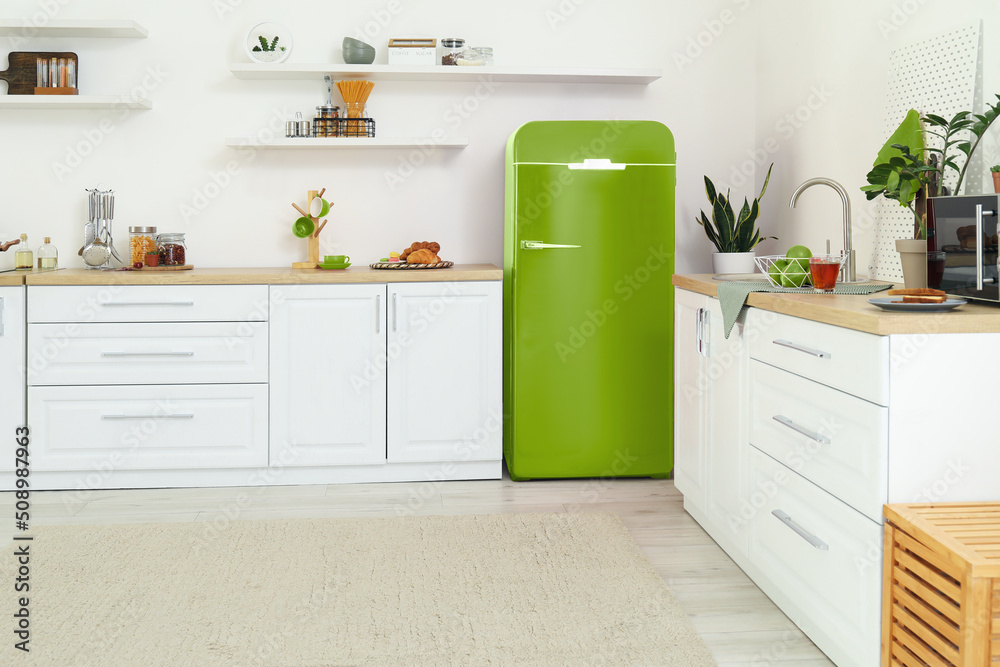 Interior of light kitchen with green fridge