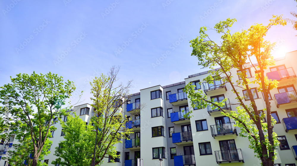 Ecological housing architecture. A modern residential building in the vicinity of trees. Ecology and