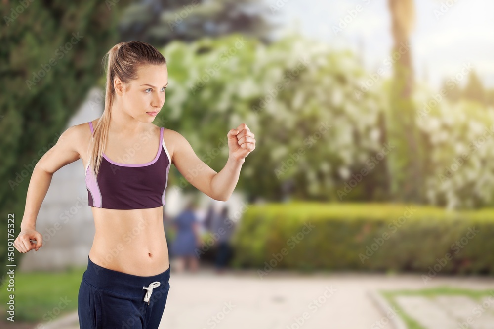 Happy slim woman wearing sportswear jogging in the city. Workout exercise in the morning. Healthy an