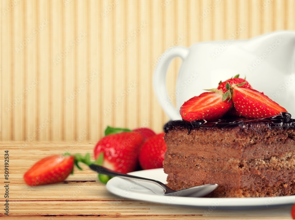 Tasty homemade chocolate cake on the plate on the desk