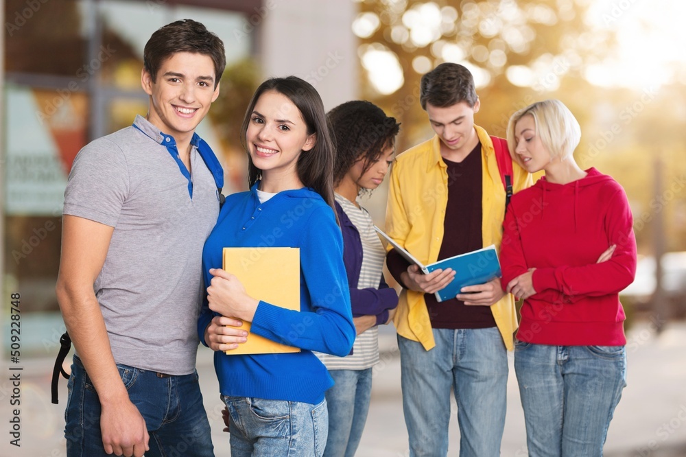 Teenage students spending time together after lessons, talking and having fun outdoors background