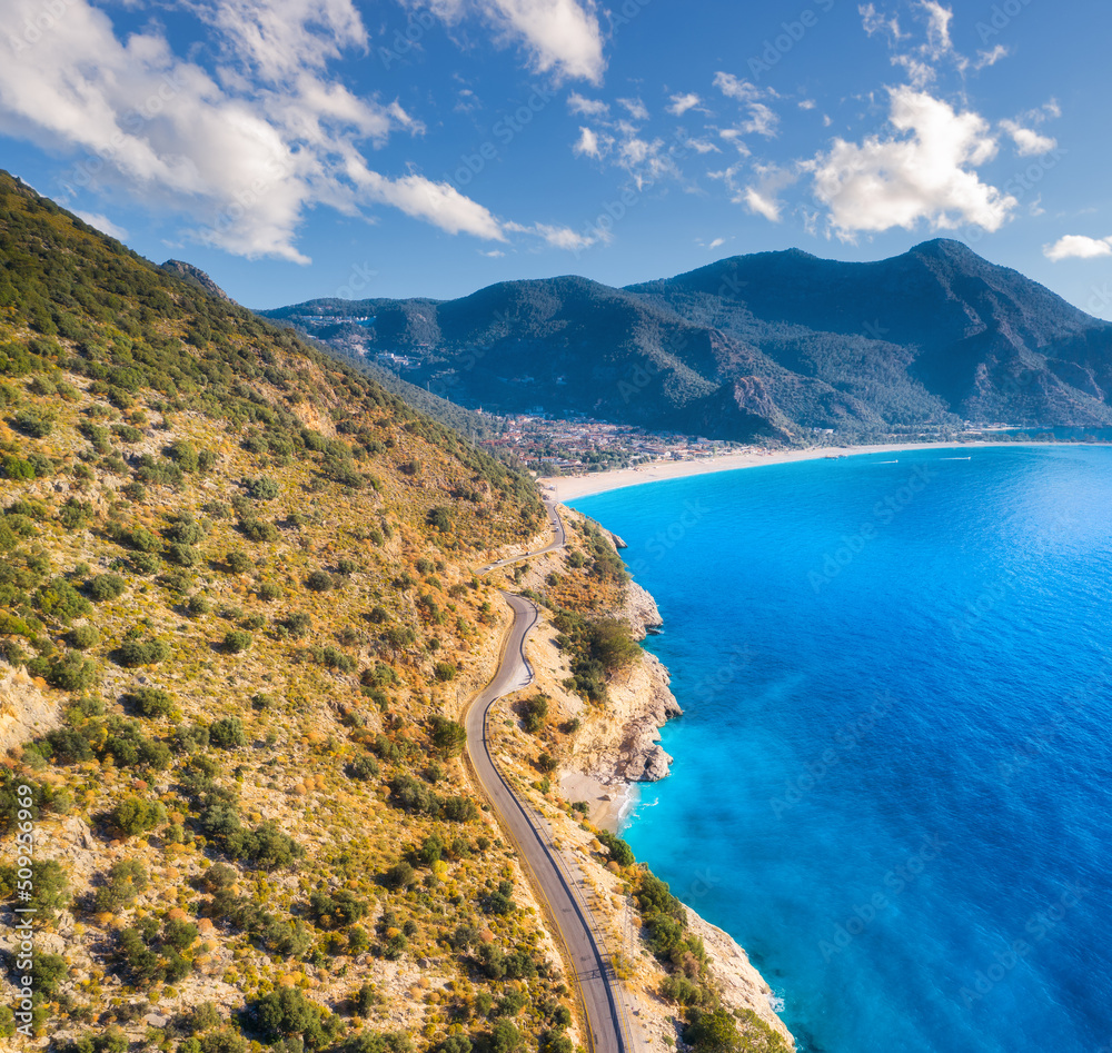 蓝色大海附近的山路鸟瞰图，夏日日落时的沙滩。土耳其奥卢代尼兹。Top v