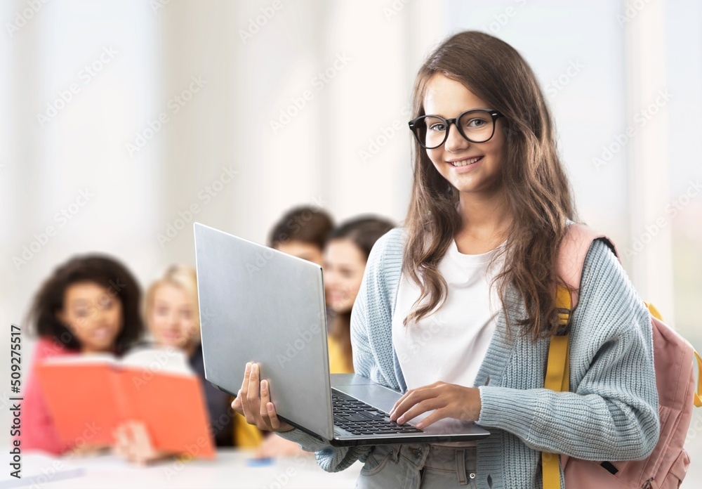 Smiling teacher during computer class at high school and looking at camera.