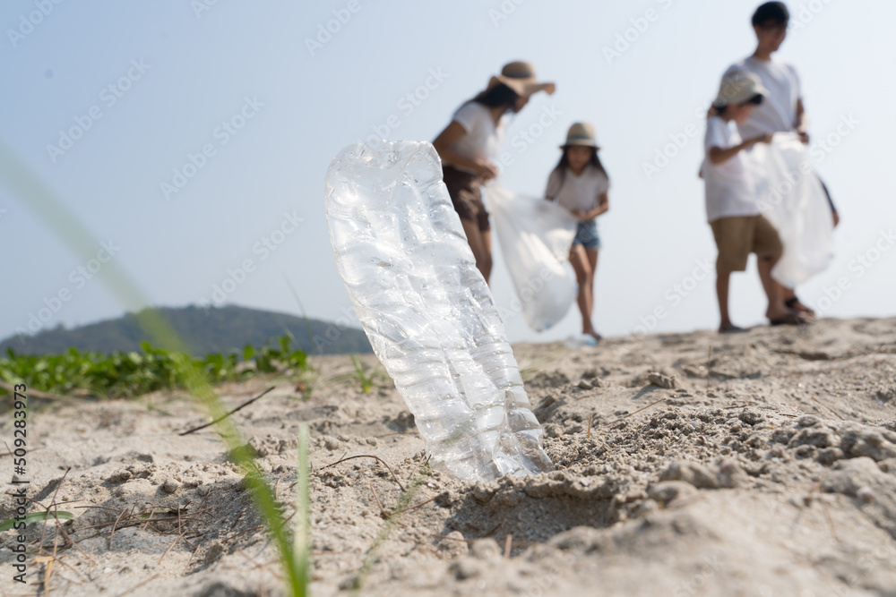 亚洲家庭志愿者在海边捡塑料瓶保护环境