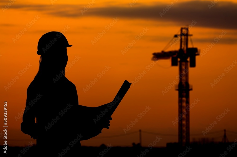 Silhouette of Engineer under inspection. Engineer man in waistcoats and hardhats and with documents.