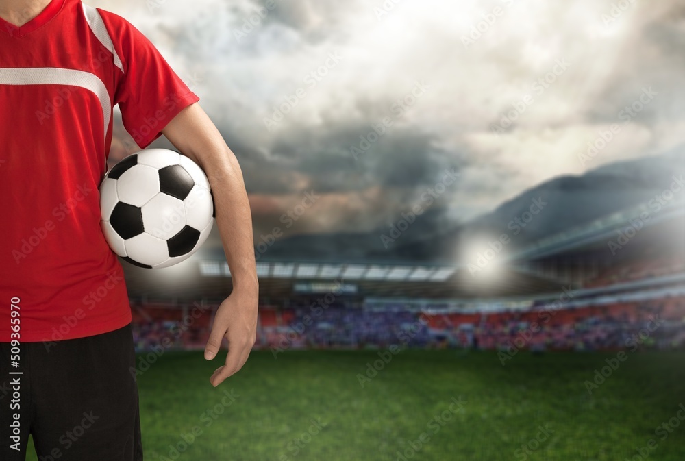 Football player with ball on stadium bakcground