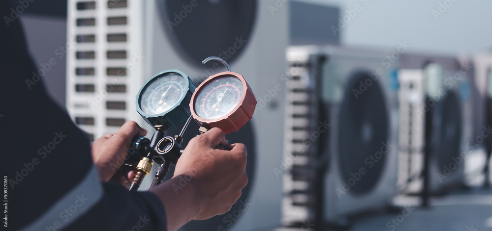 Technician is checking air conditioner ,measuring equipment for filling air conditioners.