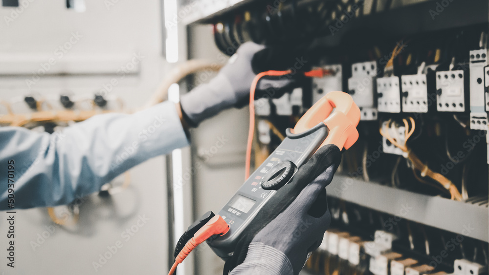 Electrical engineers test electrical installations and wiring on protective relays, measuring them w