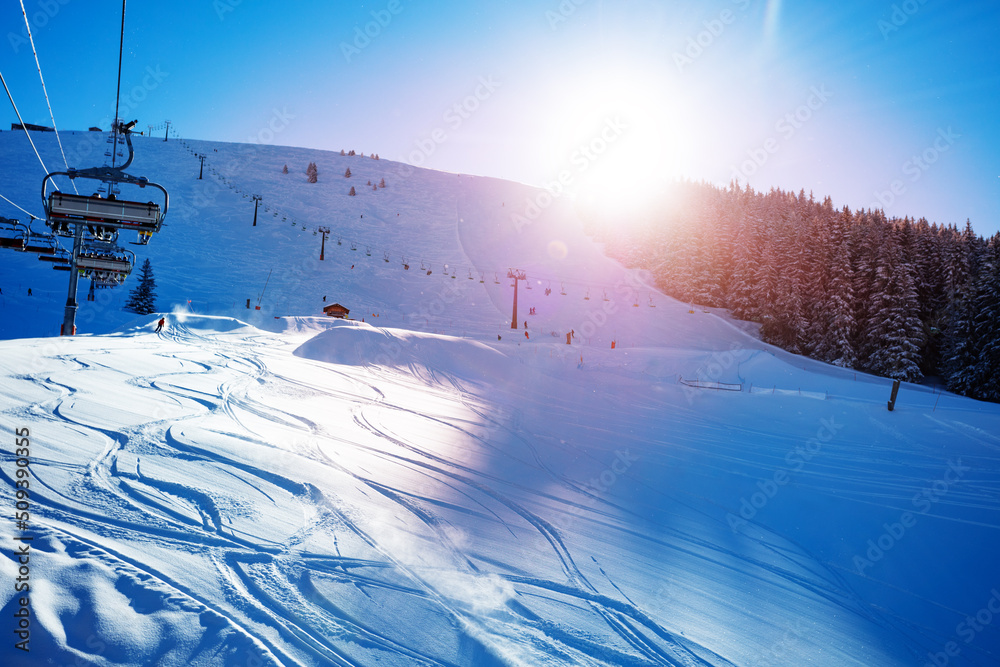 Ski lift on alpine resort with sunset over mountain range