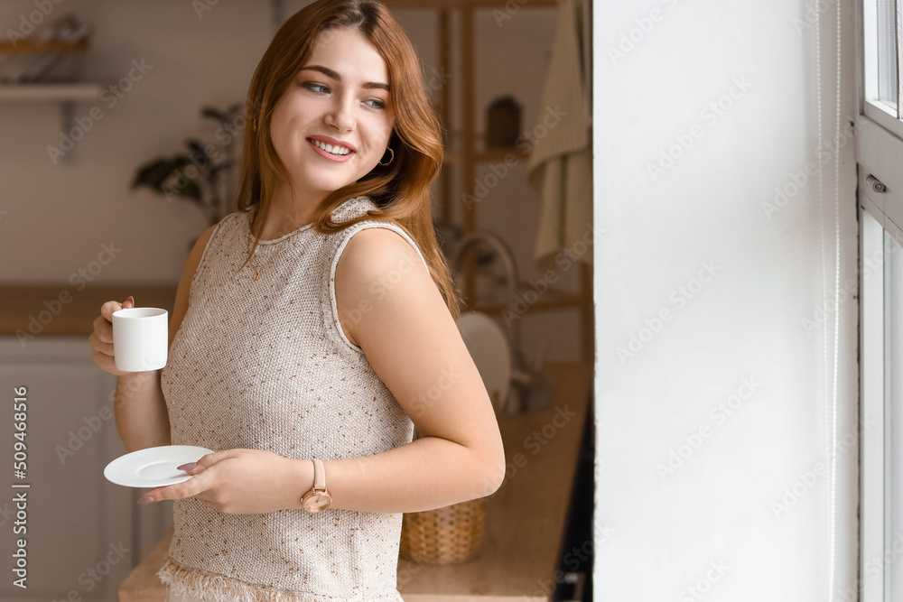 Morning of beautiful young woman drinking coffee in kitchen