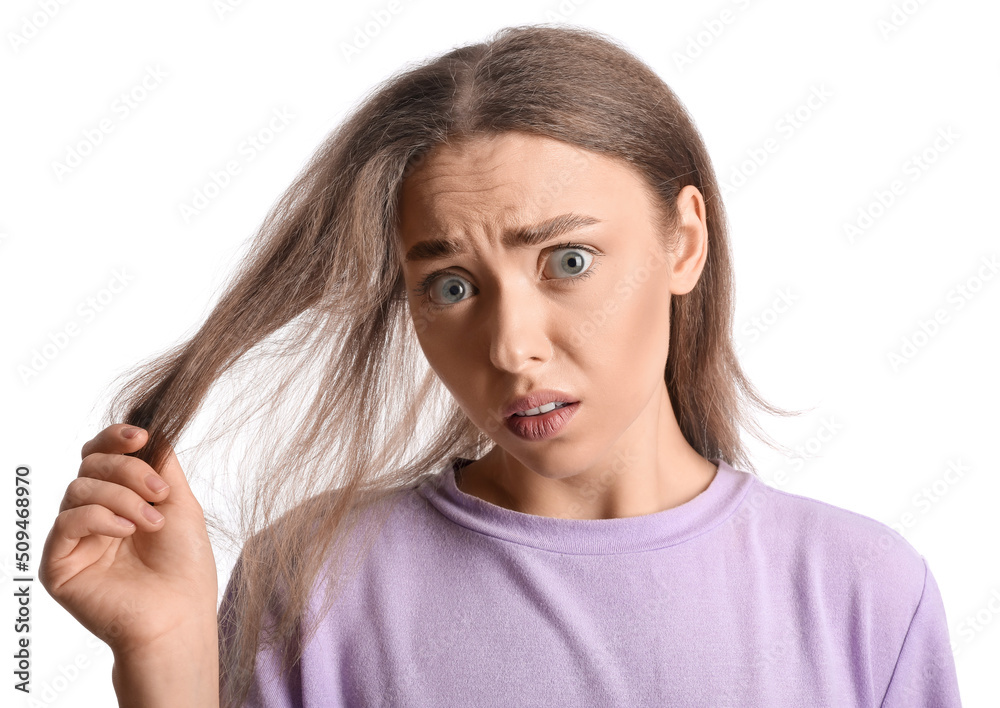 Stressed young woman with hair loss problem isolated on white