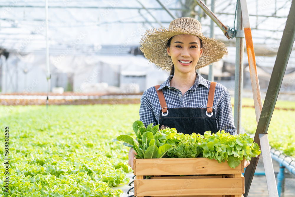 亚洲农民的画像——一位年轻女子在农场里拿着一篮子蔬菜。