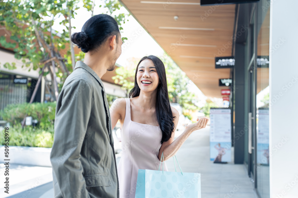 亚洲年轻男女在百货公司户外购物。