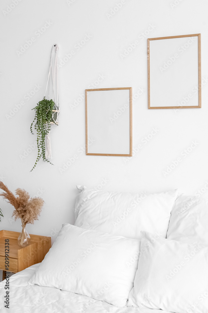 Interior of modern bedroom with blank frames