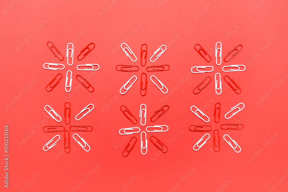 White and red paper clips on color background