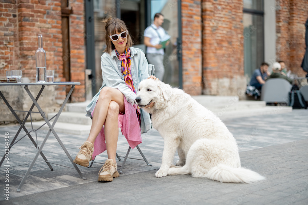 Woman cares her white dog at cafe