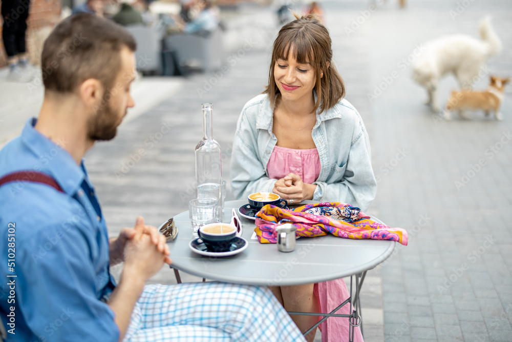 Stylish woman talks with her male colleague at cafe