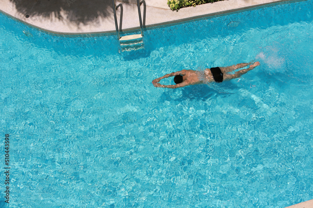 Man is swimming in pool on top view.