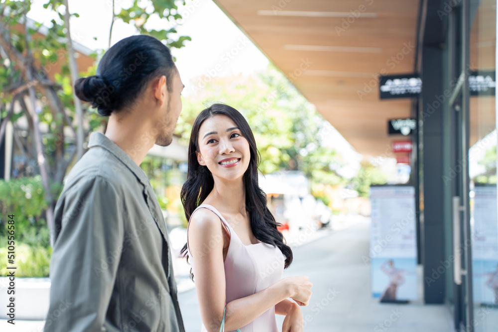 亚洲年轻男女在百货公司户外购物。