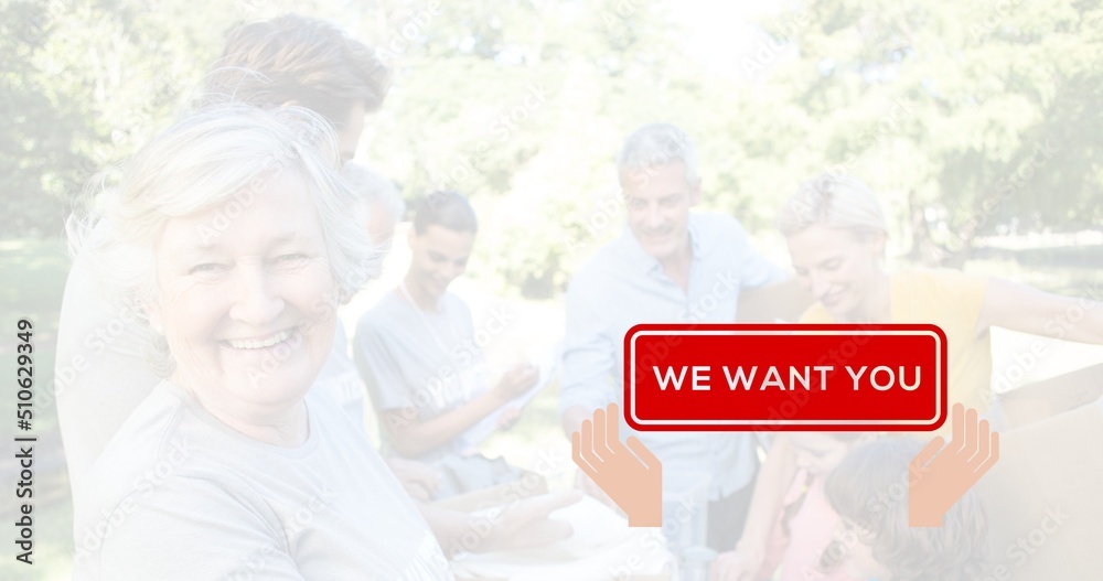 Portrait of caucasian senior woman working with volunteers at camp and we want you red text