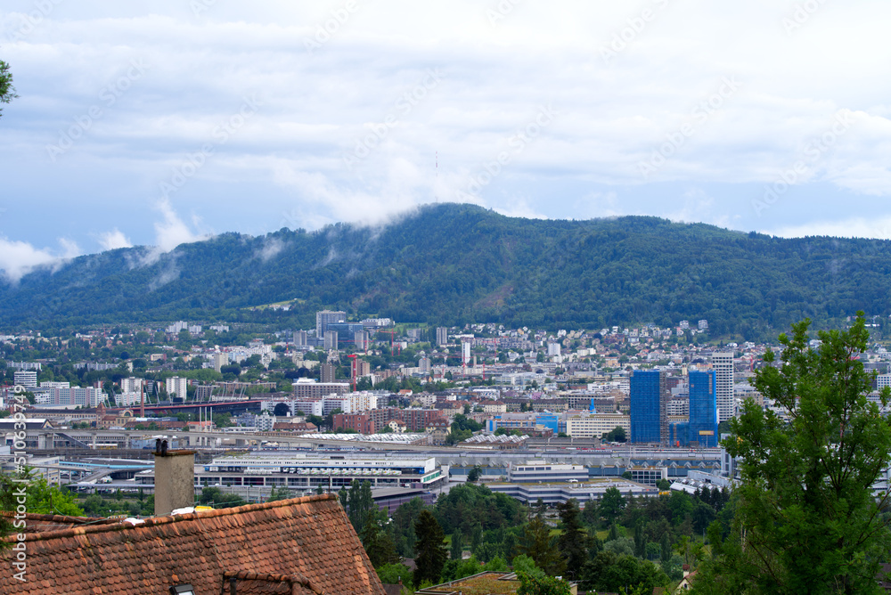 Aerial view over city of Zürich with mountains in the background seen from district Höngg on a cloud