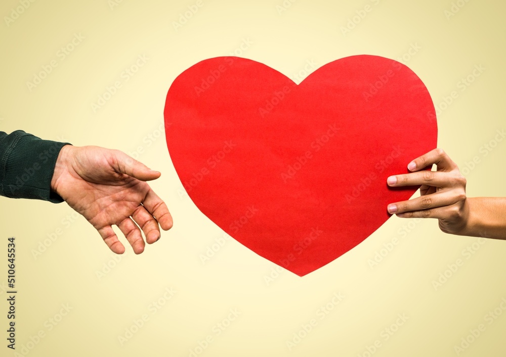 Close up of hand passing a heart shaped placard against copy space on pink background