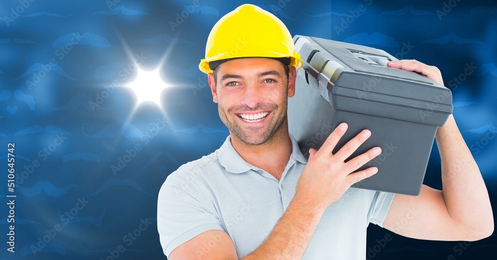 Caucasian male worker carrying a case against spot of light on blue background with copy space