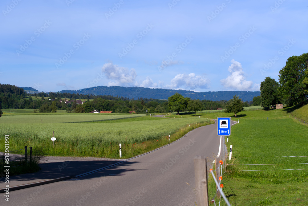 Country road with scenic rural landscape near village Forch, Canton Zürich, with traffic sign for pr