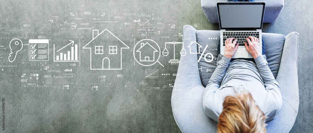 Real estate theme with man using a laptop in a modern gray chair