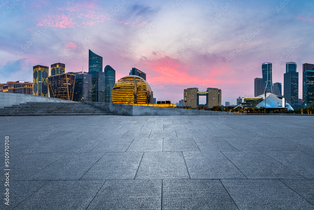 Empty square floor and city skyline with modern commercial buildings in Hangzhou at sunset, China.