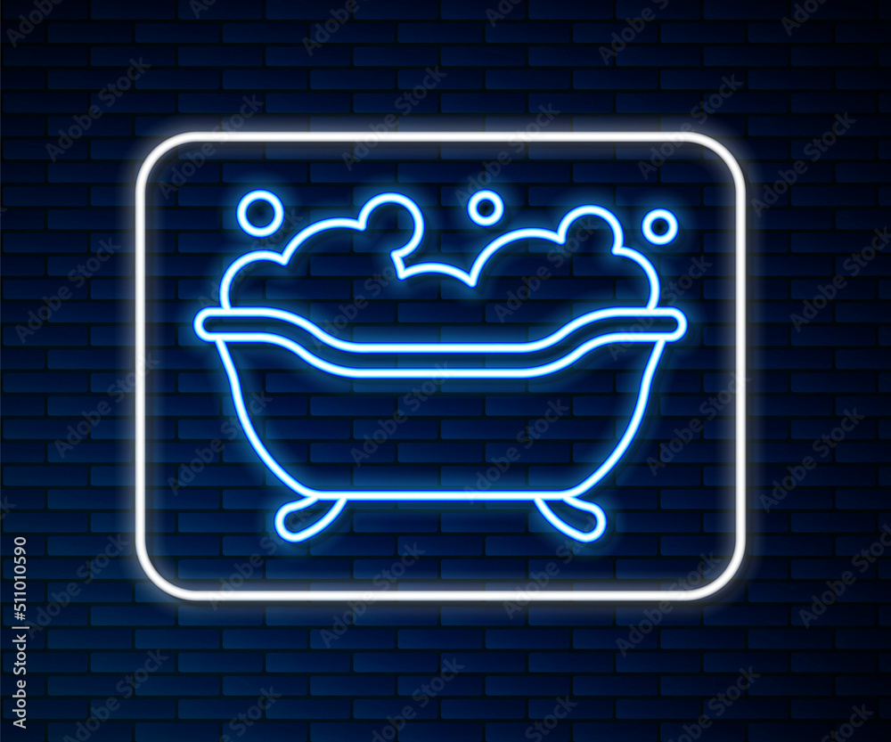 Glowing neon line Bathtub with foam bubbles inside icon isolated on brick wall background. Vector