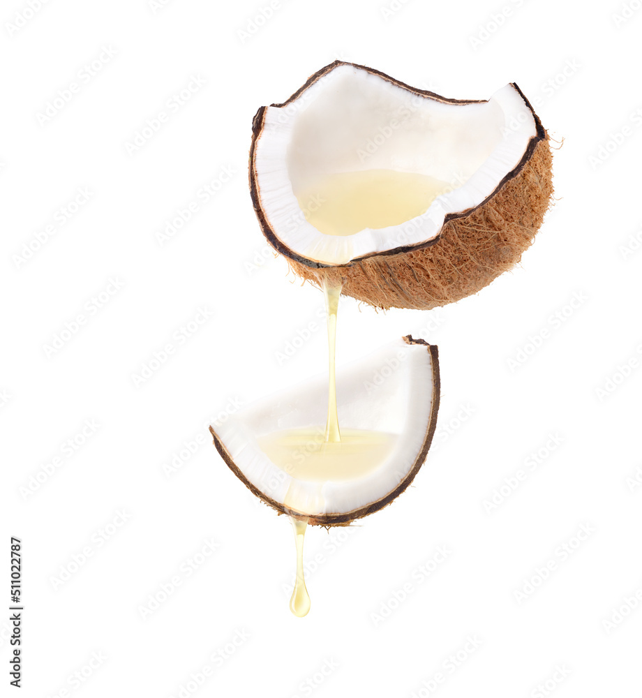 Coconut oil dripping from cracked coconut fruits  isolated on white background.