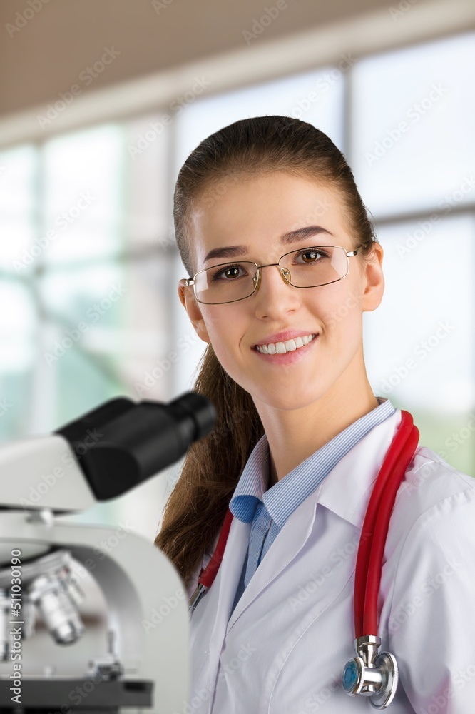 Medical research. A young scientist using a microscope in a laboratory.