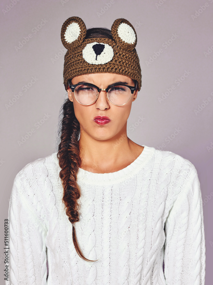 I cant bear sour faces. Studio shot of a young woman wearing a brown teddy bear beanie.