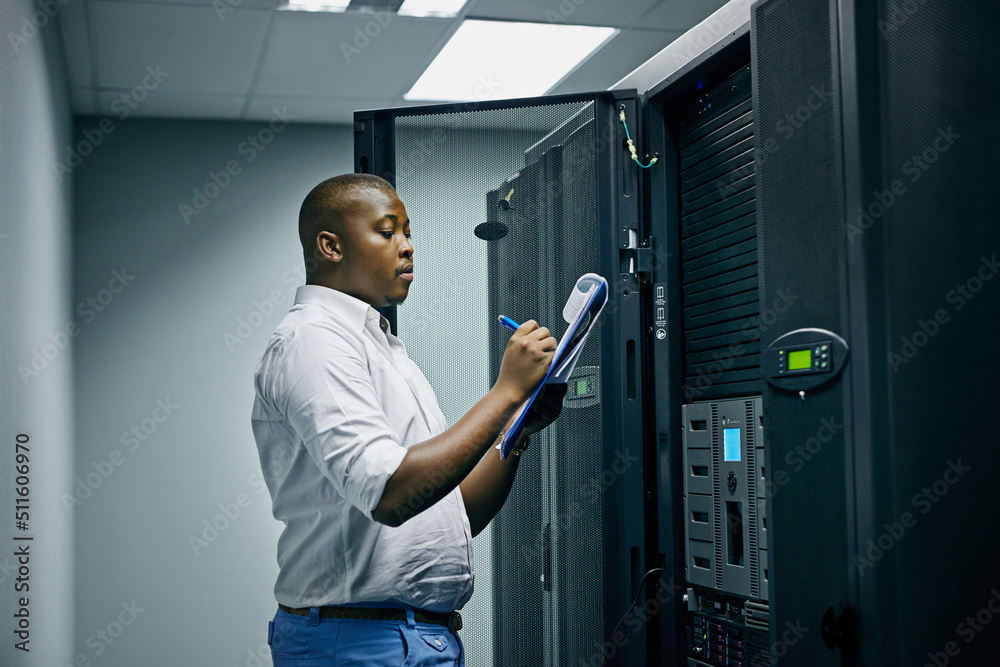 System administration done by a specialist. Shot of an IT technician doing inspections in a data cen