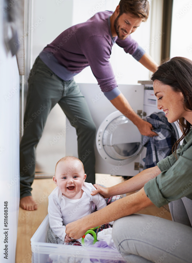 How did you get in here. Shot of a young family having fun while doing laundry.