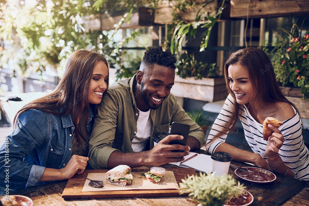 Want to see something funny. Shot of three friends looking at something on a cellphone while out for