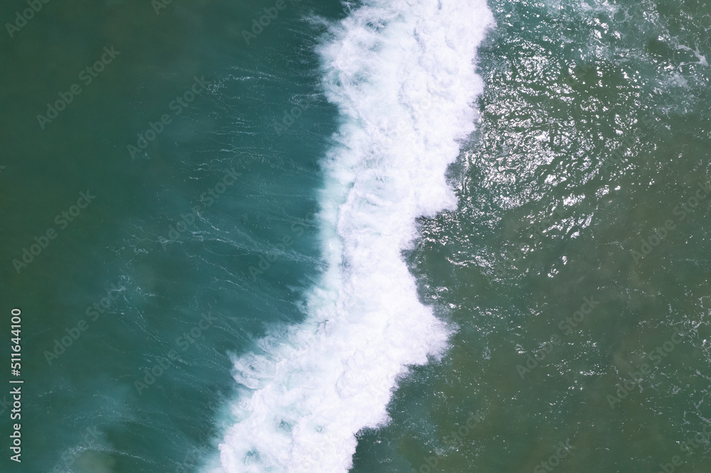 海蓝表面鸟瞰图。俯视图蓝色海水海浪，白色泡沫背景